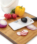Handheld Mandoline Slicer for kitchen with adjustable slices in 1mm 2.5mm 4mm on cutting board with veggies