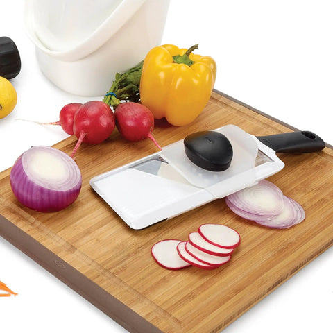 Handheld Mandoline Slicer for kitchen with adjustable slices in 1mm 2.5mm 4mm on cutting board with veggies
