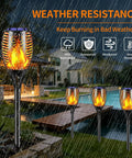 Six Pack Solar Torch Lights With Realistic Flickering Flame for Outdoor Yard Pathway Garden Patio shown in rainy weather
