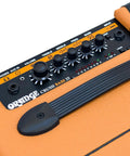 Close-up of the Orange Crush Bass 25 Watt 8 Inch Bass Amp And Speaker Combo with knobs and handle, in orange.