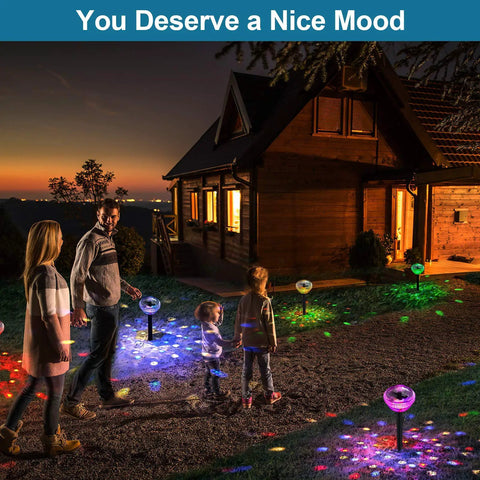 Family walking along a path illuminated by Solar Pathway Lights Outdoor 4 Pack With Auto Color Changing Waterproof Super Bright LED Path Lights For Yard Driveway Walkway Landscape Party Decor Christmas Decoration