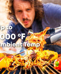 Person using ProTemp 2 Plus Wireless Meat Thermometer With Temperature Controller for grilling with flames and peppers on grill