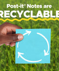 Hand holding a recyclable blue sticky note with recycle symbol and text "Post-it Notes are RECYCLABLE" on green background.