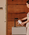 Woman filling Heavy Duty 30 Oz Vacuum Insulated Tumbler With Flip Straw Lid at modern water station