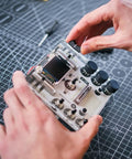 DIY DJ Mixer Kit For Beginners Teens Build Your Own DJ Board Learn Electronics Mix Tracks Add Effects Play Music Via SD Card Kid Friendly STEM Project That Feels Like Real DJing, hands assembling circuit board