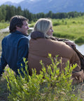 Couple outdoors with Big N Tall 20F Cold Weather Sleeping Bag For Adults Up To 6ft 4in, enjoying nature by the river.