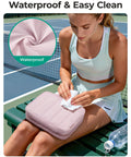 Woman wiping Travel Toiletry Bag For Women With Hanging Hook, Waterproof Cosmetic Organizer, on tennis court bench.