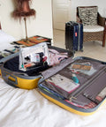 Open suitcase on bed with clear pouch, showing Two Box Set Pre Threaded Needle Kit With Twenty Pieces And Mixed Color Threads 32 Inch Length Grab And Go Quick Sewing Kit Includes Four Buttons And Four Safety Pins Perfect For Everyday Hand Sewing And Quick Home Repairs inside.