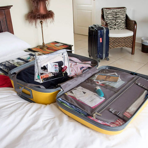 Open suitcase on bed with clear pouch, showing Two Box Set Pre Threaded Needle Kit With Twenty Pieces And Mixed Color Threads 32 Inch Length Grab And Go Quick Sewing Kit Includes Four Buttons And Four Safety Pins Perfect For Everyday Hand Sewing And Quick Home Repairs inside.