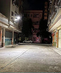 Top Shelf Solar Powered Outdoor Wall Light Featuring Smart Motion Sensor illuminating a dark street at night.