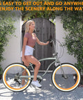 Woman standing beside a Fat Tire Cruiser Bike With 7 Speed Shimano, Iconic Stretch Chopper Frame in grayish orange finish.