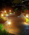 Retro Bronze Metal Solar Lanterns Outdoor Lights Pack Of 2 illuminating a garden path with warm LED glow, vintage style in the dark.
