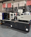 Top Shelf Hydraulic Injection Molding Machine For Plastic Chair Production And Household Goods Custom Industrial Workhorse Crank Out Multi Material Parts Daily in industrial setting with control panel and materials.