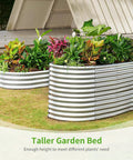 Oval Galvanized Raised Garden Beds 6x3x3 Feet With Large Capacity Metal Planter Box For Outdoor Use Deep Three Foot Tall Design Reducing Bending And Making Veggie Gardening A Breeze In Classic Silver placed outdoors with vibrant plants