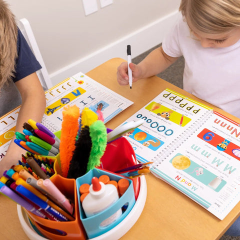 Rotating Art Supply Organizer With Six Colorful Cups That Holds Crayons Markers And Pencils Kid Friendly Desk Caddy For Classroom Or Home Use Easy Grab And Go Access on a table with kids drawing.