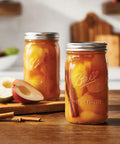 Real Deal Wide Mouth Glass Mason Jars With Lids And Bands For Canning And Pickling Quart 32 Oz Pack Of 2 filled with spiced apples.