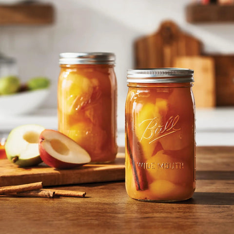 Real Deal Wide Mouth Glass Mason Jars With Lids And Bands For Canning And Pickling Quart 32 Oz Pack Of 2 filled with spiced apples.