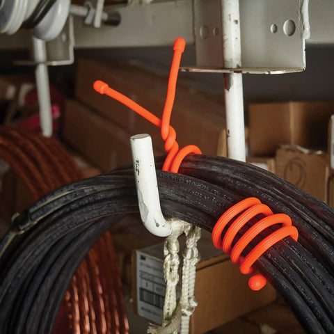 Gear Tie Reusable Rubber Twist Ties 8 Pack Assorted Colors For Wires And Cables DIY Projects And Home Organization Made In The USA Flexible Grip Ties With Bendable Wire securing thick black cables in workshop.