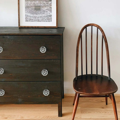 Wooden dresser with Chrome Flower Drawer Knob Set Zinc Cabinet Pulls 4 Pack With 3 Screw Sizes for bedroom dresser, next to a chair.
