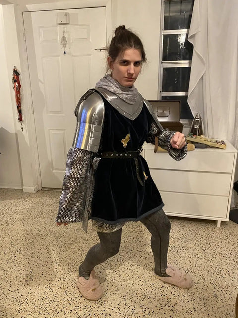Person wearing Medieval Iron Gorget Spaulders And Vambraces Armor Set For Cosplay Lovers with adjustable leather straps indoors.