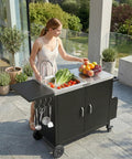 Woman using Outdoor Grill Cart With Movable Prep Table And 304 Stainless Steel Sink, Rolling Kitchen Island With Cabinet on patio