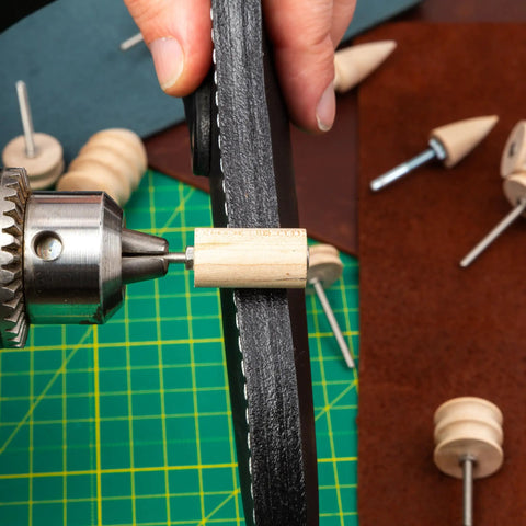 Hand holding leather against rotary tool with 12 Piece Leather Edge Burnishing Bits For Rotary Tools Leather Polishing Bits.