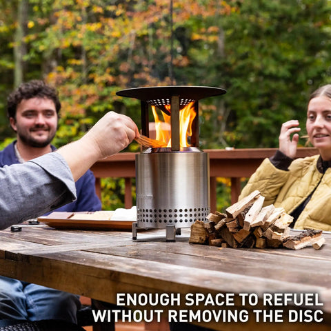 Mesa XL Heat Deflector With 3 Detachable Legs for Fire Pit showing stainless steel build next to people on outdoor patio