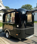 Top Tier 10ft Slick Black Mobile Food Truck For Coffee Kiosks And Pop Up Catering With Reliable Walk Up Fridge Unit Factory Direct Certified Build Ready To Hustle Hard, showing a black mobile coffee cart with opened windows.