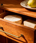 10 Pack 5 Inch Center To Center Antique Brass Kitchen Cabinet Pulls on a wooden drawer with cheese and butter.
