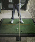 Durable Steel Golf Swing Plane Trainer Plate With Alignment Stick Holder on a practice mat, golfer preparing to swing.