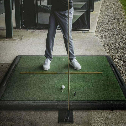 Durable Steel Golf Swing Plane Trainer Plate With Alignment Stick Holder on a practice mat, golfer preparing to swing.