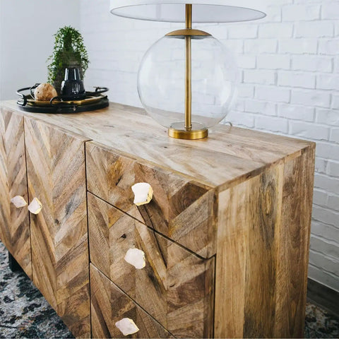 Four Crisp White Geode Cabinet Knobs With Burnished Gold Plating Designed To Level Up Your Kitchen Drawers Bedroom Dressers And Closet Doors While Adding A Clean Modern Vibe To Any House on a wooden dresser.