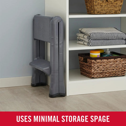 Two Step Folding Foot Stool 14 Inch High Gray Lightweight 300 Pound Capacity folded beside shelf in home