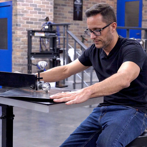 Craftsman using Bead Roller Tool for Metal Fab with 22mm Shaft Tipping Die in workshop, creating intricate bead patterns on sheet metal.