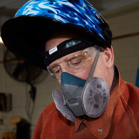 Person wearing P100 Advanced Respirator Filter 2297 Pair with heavy-duty protection in industrial setting