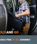 Man lifting Sidekick Folding Work Table Portable All-In-One Work Bench into car, emphasizing foldable and portable design for easy transport.