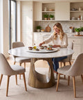 Built Tough 47 Inch Round Dining Table With White Sintered Stone Top And Legit Smooth Rotating Lazy Susan For Chowing Down With Two To Six Guests Hangout Style, with a woman serving food.