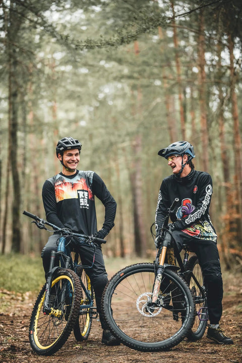 Two mountain bikers on a forest trail with bikes equipped with Front Bike Fender For Face And Suspension Fork Protection