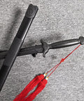 Tai Chi Sword Training Katana Style Practice Sword, 99cm High Elastic Polypropylene Blade With Scabbard And Red Tassel displayed on carpet