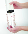 Two Cup Adjustable Measuring Cup with Grippy Rotating Body, silicone disc, inner track, held between hands.