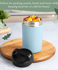 Heavy Duty Double Wall Vacuum Sealed Stainless Steel Food Jar With Rugged Carry Handle Lid Keeps Your Lunch Sizzling Hot All Day Leakproof Grab And Go Sixteen Oz Sky Blue with fruit inside on wooden surface.