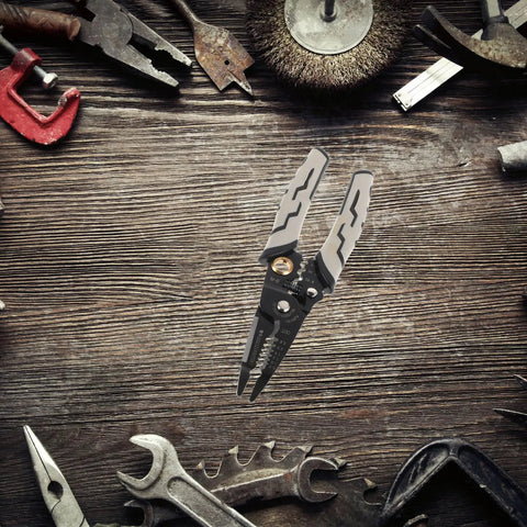 Pretyzoom 7-In-1 Cable Stripper And Crimper For Electricians on a wooden surface among various tools.