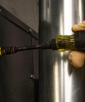 User holding Tough As Nails 16In1 Hybrid Screwdriver with heavy duty magnet on metal surface.