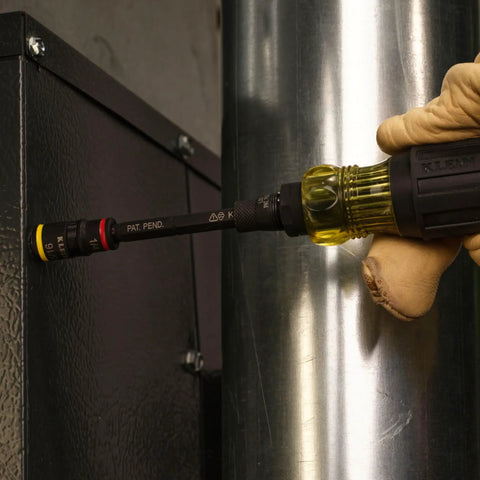 User holding Tough As Nails 16In1 Hybrid Screwdriver with heavy duty magnet on metal surface.