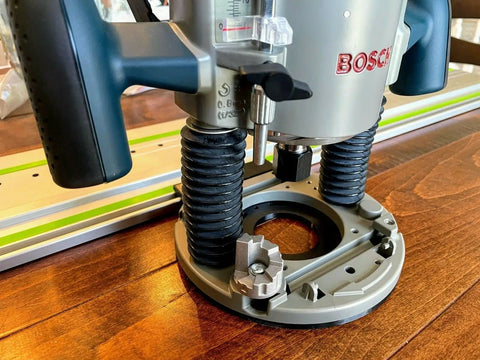 Guide Rail Adapter Fits Bosch 1617 Router Converts Plunge Or Fixed Base To Track Saw System For Dead On Cut Accuracy Uses Original Sub Base Screws For A No Sweat Install Designed And Built In America, close-up of Bosch router base on wooden surface.