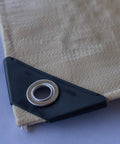 Close-up of corner grommet on Heavy Duty Waterproof Tarp 20 Ft By 30 Ft 12 Mil Thick Tan Tarp With Reinforced Corners And Rope Hem