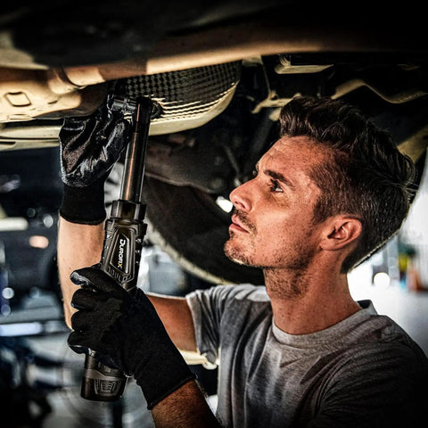 Mechanic using 12V Li-Ion Cordless 3/8 Inch Extended Drive Ratchet Wrench Kit With Built-In LED Light underneath a vehicle