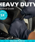 Hands wearing Heavy Duty Nitrile Disposable Gloves, 8 Mil Thick, Black Diamond Textured Finish, gripping a tire bolt