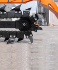 Workhorse Skid Steer Trencher Attachment with beefy steel frame and tungsten carbide teeth on pavement