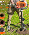 Man operating orange Gas Powered Post Hole Digger Auger with 62CC Engine and 2 Stroke Power on grassy lawn